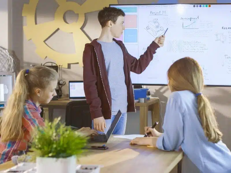 Étudiants à l'université travaillant sur un tableau blanc interactif