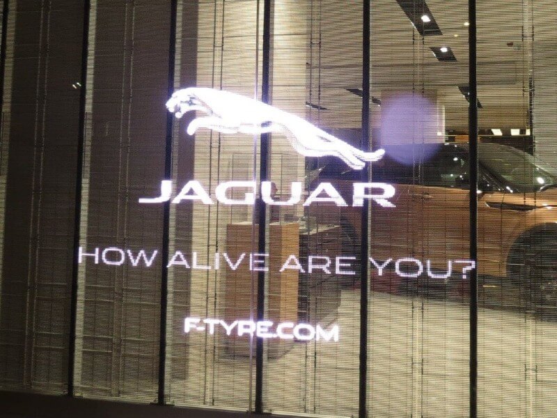 Panneau LED transparent sur la vitrine de la concession automobile Jaguar