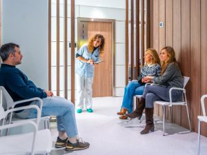 Assistante accueillant les patients dans la salle d'attente d'un cabinet dentaire