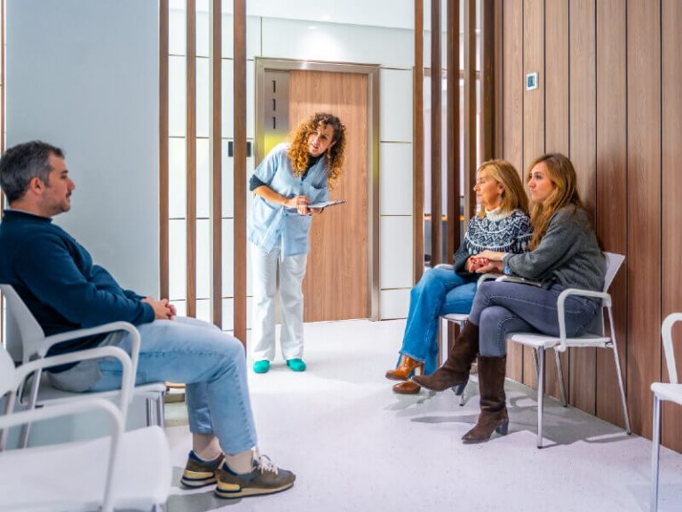 Assistante accueillant les patients dans la salle d'attente d'un cabinet dentaire